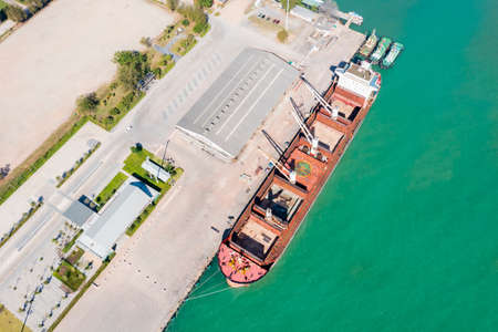 Aerial drone top view of containers cargo ship at industrial import-export port. Business logistic import and export freight transportation by container ship in open seaの写真素材