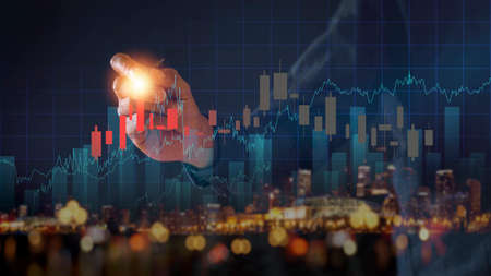 Businessman writing analyze graph for trade stock market on the screen. Businessman hand drawing chart graph stock of growth. Hand man uses pen to draw stock graph chart point of target success.の写真素材