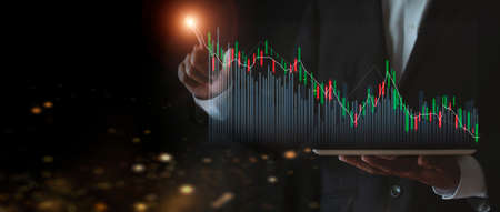 stock market growth up. Businessman holds tablet and displays holographic graph showing statistics of profitable graphs. Ideas of growth planning and business strategies to see trends in good businessの写真素材