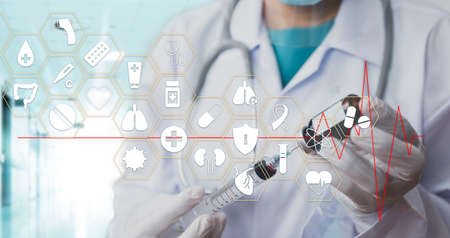 Medicine doctor with stethoscope in hand hold syringe icon medical network connection on virtual screen interface. Modern medical technology and innovation concept. Medical and health conceptの写真素材