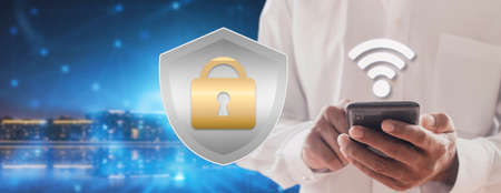 Businessman use smartphone contract to prevent probability of risks in cyber security and checking details in the phone. Padlock and shield hologram iconsの写真素材