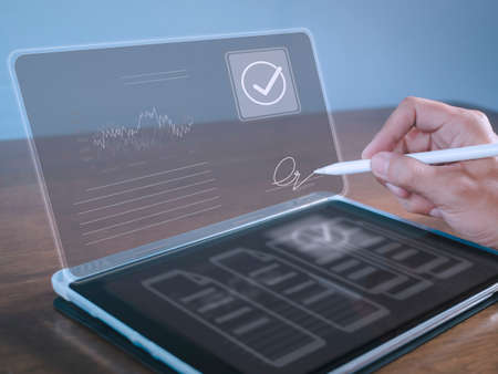 businessman use electronic pen sign signature on electronic  E-signing, data sheet document management, paperless office concept. Businessman using stylus pen signing e document on digital tablet.の写真素材