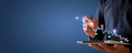 Businessman hand using tablet with creative glowing arrow and stock chart Hand of businessman use tablet analysis stock market graph growth increase chart positive indicators with copy space bannerの写真素材