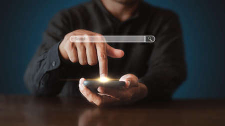 Hand man using mobile phone with search bar connect to social media, social network Online marketing concept Man hand holding smartphone with search bar Lifestyle business concept copy space bannerの写真素材