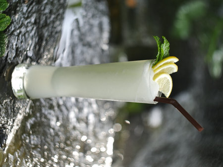 fruit juice, fruit smoothie, fruit juice, fruit juice in glass Placed on a rock near the waterfall.の写真素材