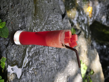 fruit juice, fruit smoothie, fruit juice, fruit juice in glass Placed on a rock near the waterfall.の写真素材