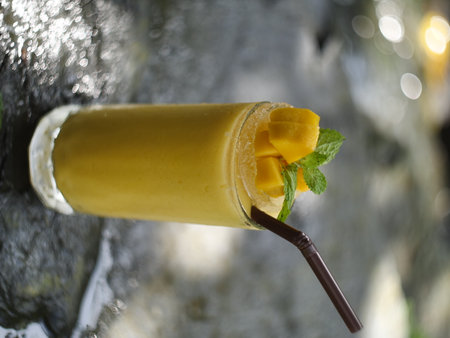 fruit juice, fruit smoothie, fruit juice, fruit juice in glass Placed on a rock near the waterfall.の写真素材