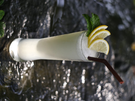 fruit juice, fruit smoothie, fruit juice, fruit juice in glass Placed on a rock near the waterfall.の写真素材