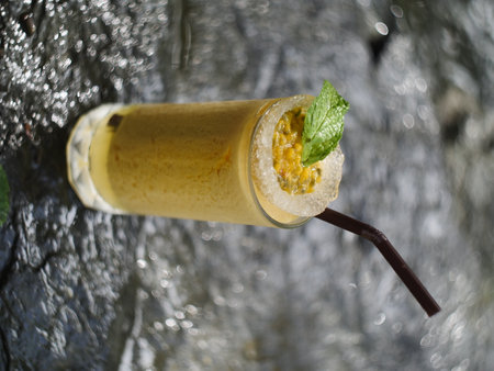fruit juice, fruit smoothie, fruit juice, fruit juice in glass Placed on a rock near the waterfall.の写真素材
