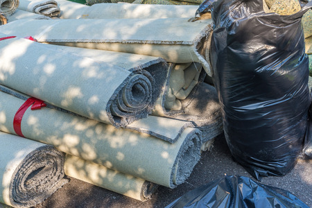 old carpet rolls removed from hpme and ready to be throw outの写真素材