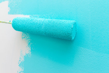 Person painting wall with roller