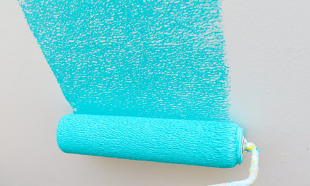 Person painting wall with roller
