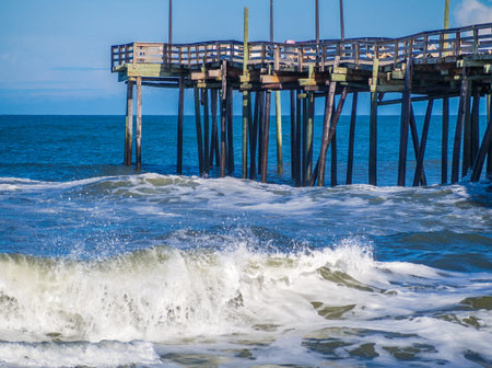 Old wood fishing pier at the sandy beachの写真素材