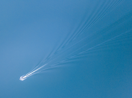 Aerial photo of motor boat running on blue lakeの写真素材
