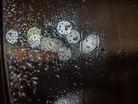 Look at city lights through wet windowの写真素材