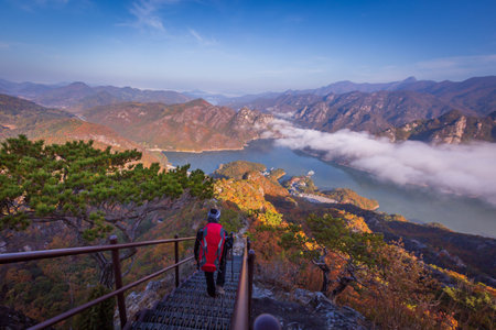 tourist with backpack admiring landscape in Autumn In the morning, a sea of â€‹â€‹mist...