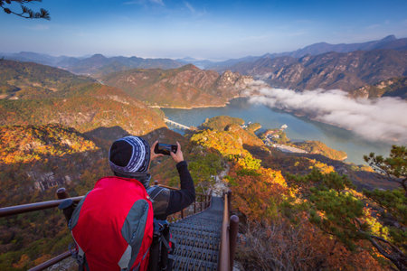 tourist with backpack admiring landscape in Autumn In the morning, a sea of â€‹â€‹mist...