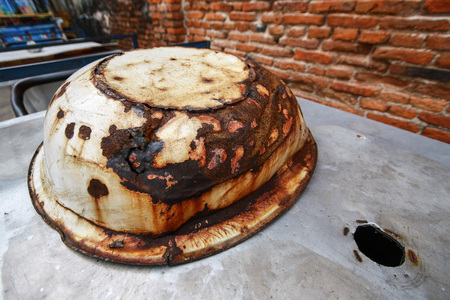 The pot is rust on the stainless steel plate next to the brick wallの写真素材