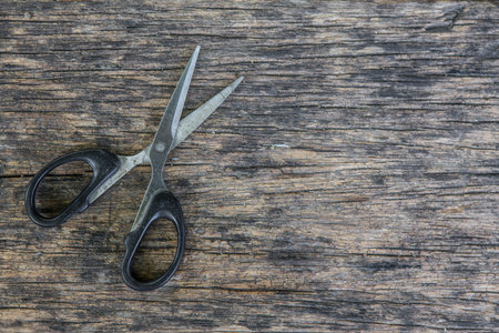 Scissors on the old wood texture background