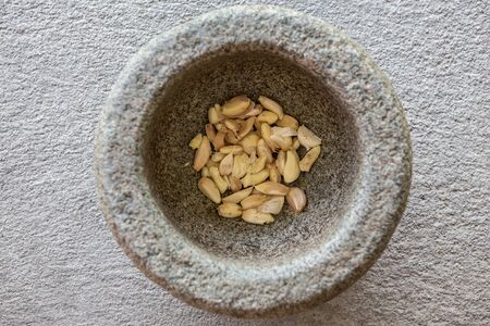 Garlic in stone mortar on the concrete floorの写真素材