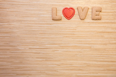 Bread alphabet "LOVE" and Red heart on the wooden table backgroundの写真素材