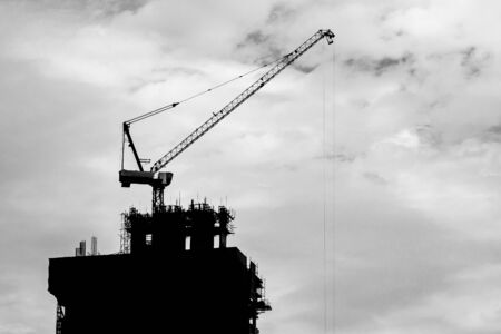 Silhouette of Crane on the building under constructionの写真素材