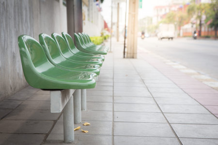 Close up Green seat in the bus stop on the sidewalk with sunlight background