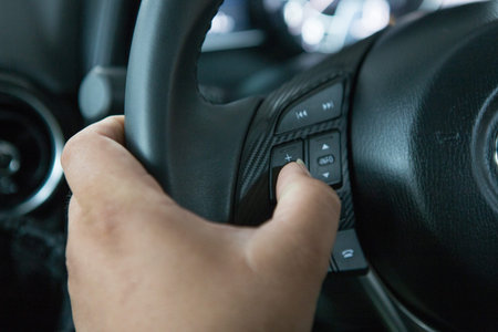 Men's hand holding the steering wheel