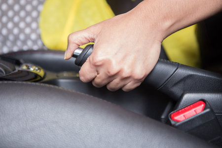 Woman hand holding a hand brake in the carの写真素材