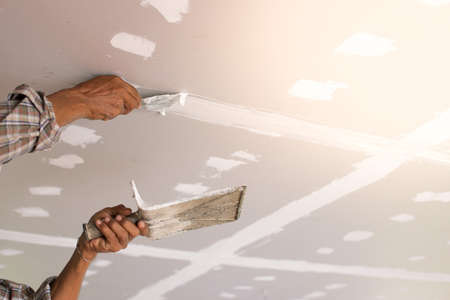 Hands of Workers are repairing the ceilingの写真素材