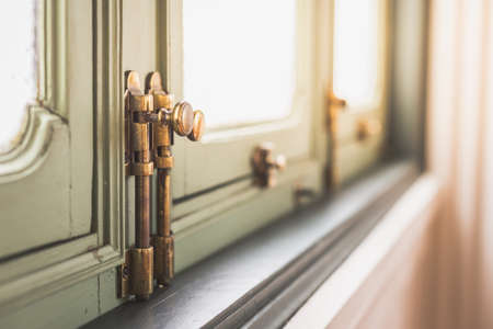 Selective focus of Brass Bolt on Antique Window with warm lightの写真素材