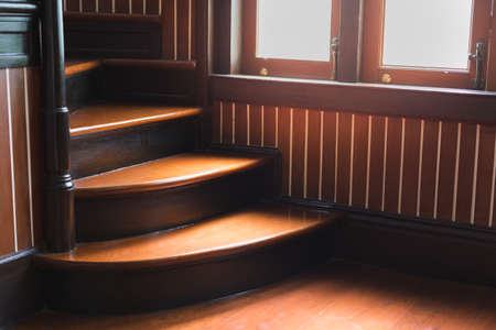 Wooden stairs in an ancient house with warm light from windowsの写真素材