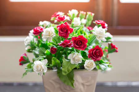 Bouquet of white and red roses in small vases with warm light backgroundの写真素材