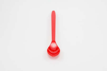 Red plastic spoon on white backgroundの写真素材
