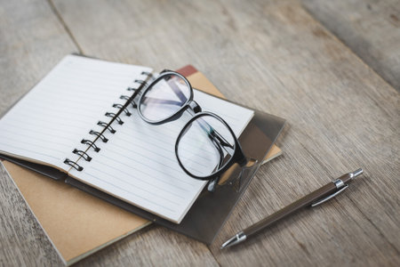 Selective focus of Pen, notebook, glasses on the wooden tableの写真素材