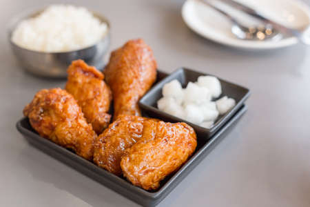 Korean Style Fried Chicken in Black Dish in Restaurantの写真素材