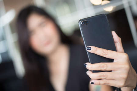 Selective focus of Woman holding a smartphone for Selfieの写真素材