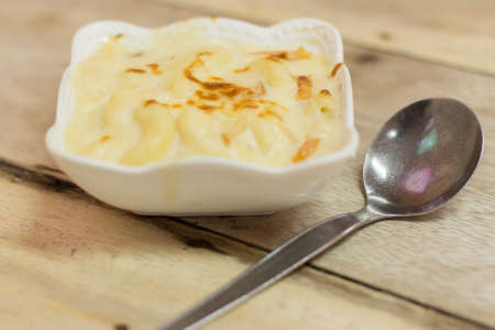 Au Gratin in a white bowl on a wooden tableの写真素材