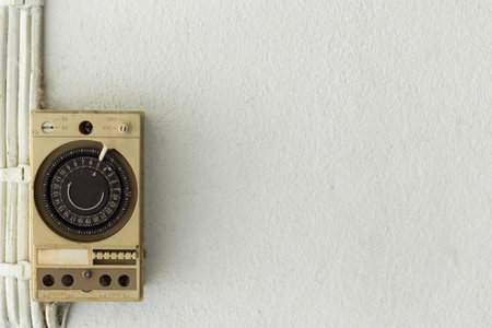 Old Electric timer on the white wall background and copy space