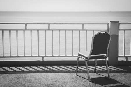 Black and white of Terrace chairs on the sky and sea backgroundの写真素材
