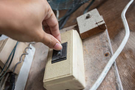 Hand is holding the old breaker switchの写真素材
