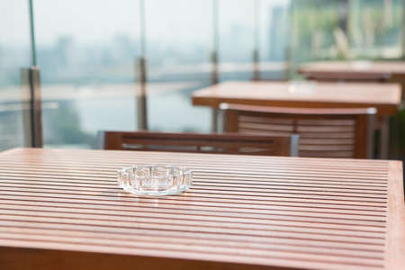 Ashtray on the wooden table at an outdoor cafeの写真素材