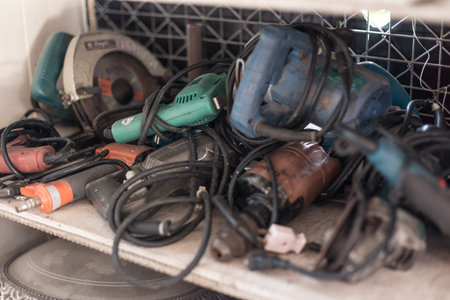 Many old electric drills on the shelves in the workshop