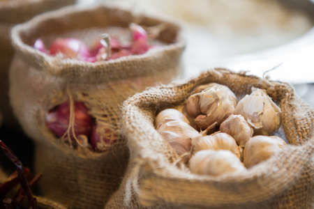 Close up of Garlic in cloth sacks on blurred backgroundの写真素材
