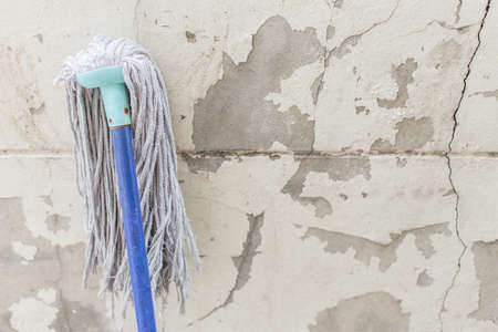 Mop on the old wall texture background and copy spaceの写真素材