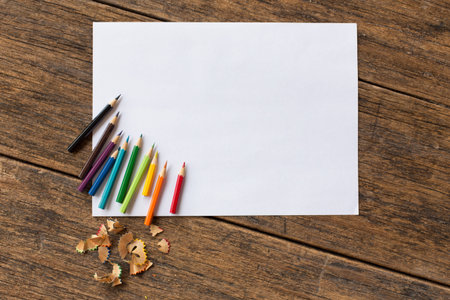 colorful colored pencil and white paper on wooden backgroundの写真素材