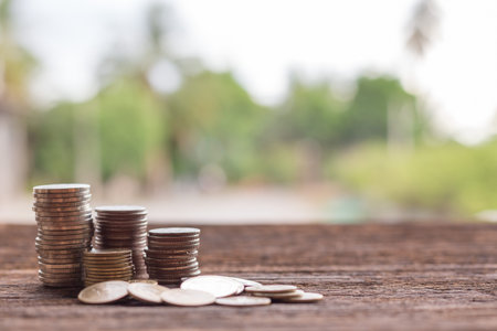 Stack of coins on wood on blurred background