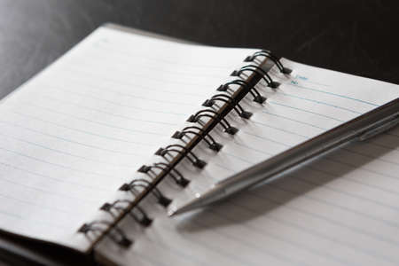 Selective focus of Pen, notebook, on black background and copy spaceの写真素材