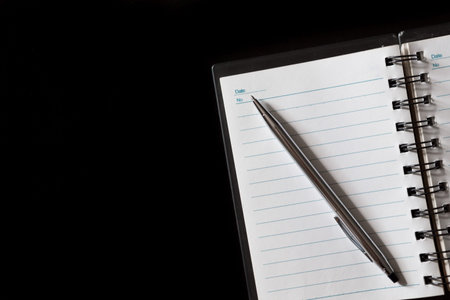 Top view of Pen, notebook on black background and copy space