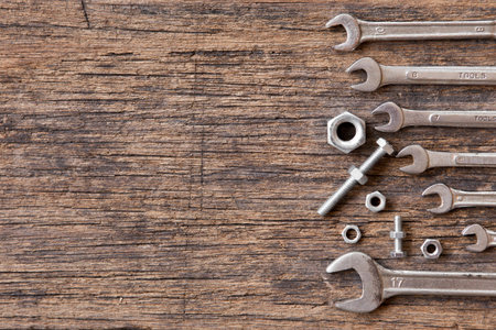 Top view of Many wrench with nuts and bolts on wood background and copy space